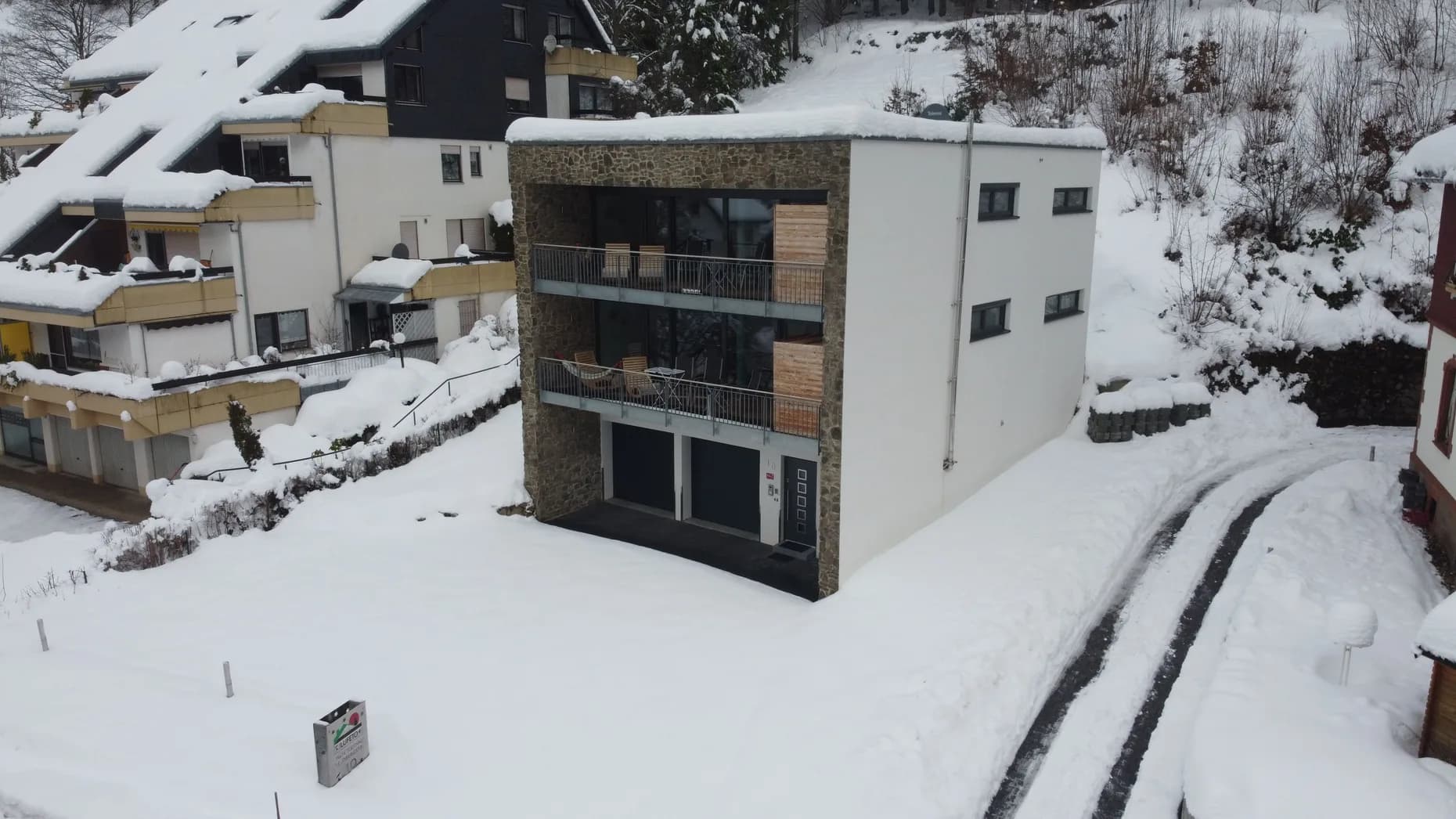 Haus LuFeTo im Schnee, Luftaufnahme mit geräumter Zufahrt