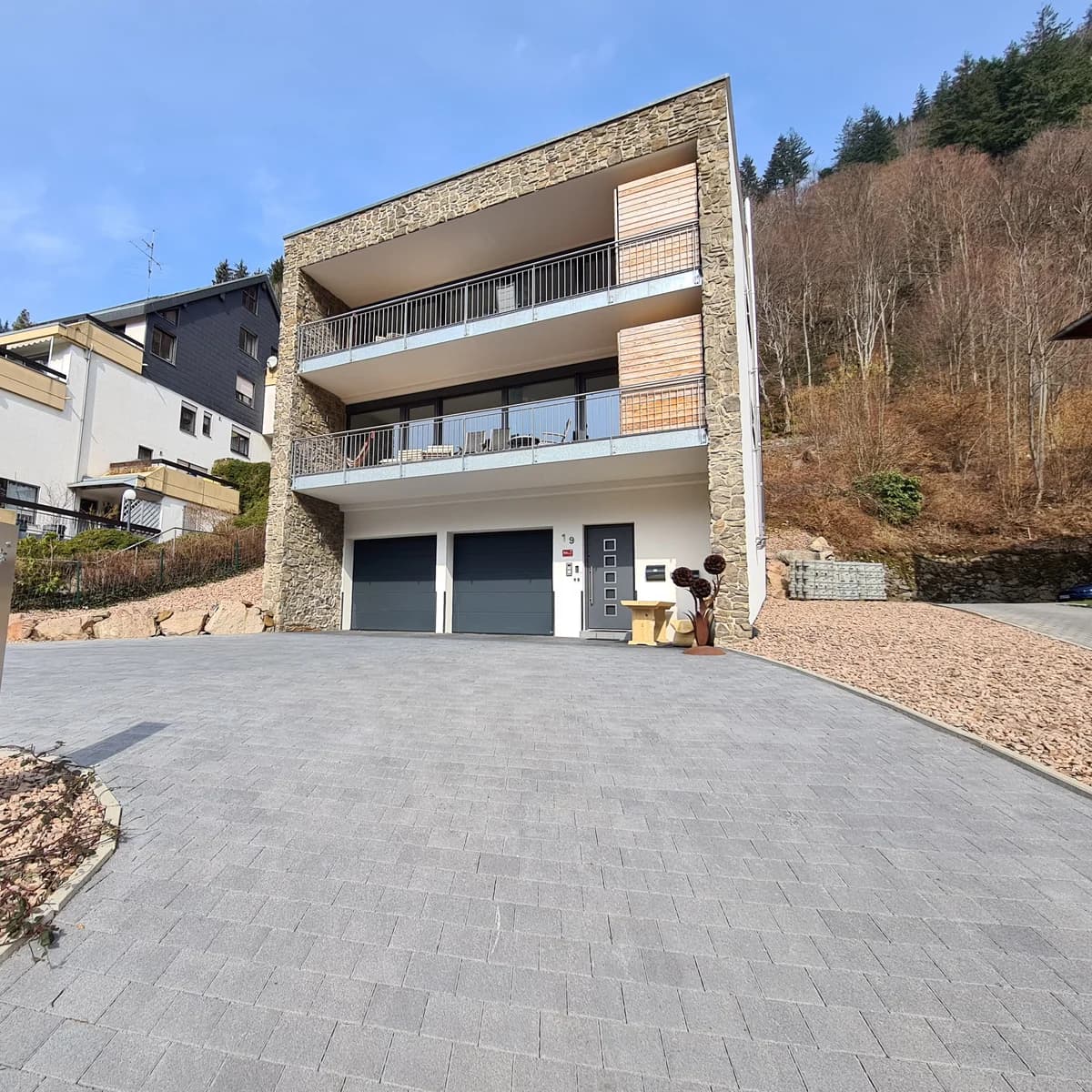 Haus LuFeTo in Todtnau von aussen, Natursteinfassade, zwei Balkonebenen und die Garagen im Erdgeschoss
